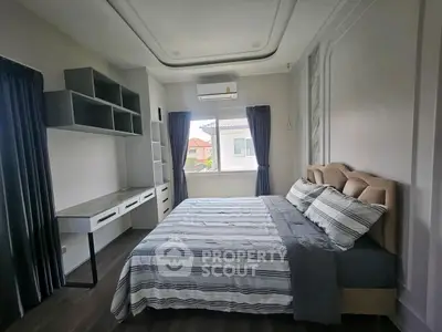 Spacious bedroom with modern design and ample natural light, featuring a cozy bed and built-in storage.