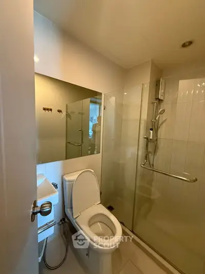 Modern bathroom with glass shower and sleek fixtures in a contemporary apartment.