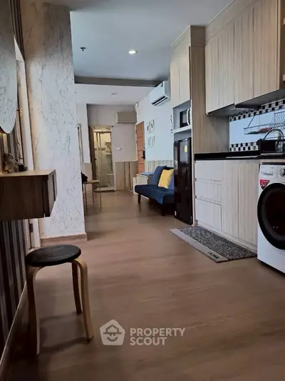 Modern open-plan living area with stylish kitchen and cozy seating, perfect for urban living.