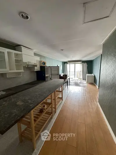 Spacious kitchen with open layout and natural light, featuring modern appliances and wooden flooring.
