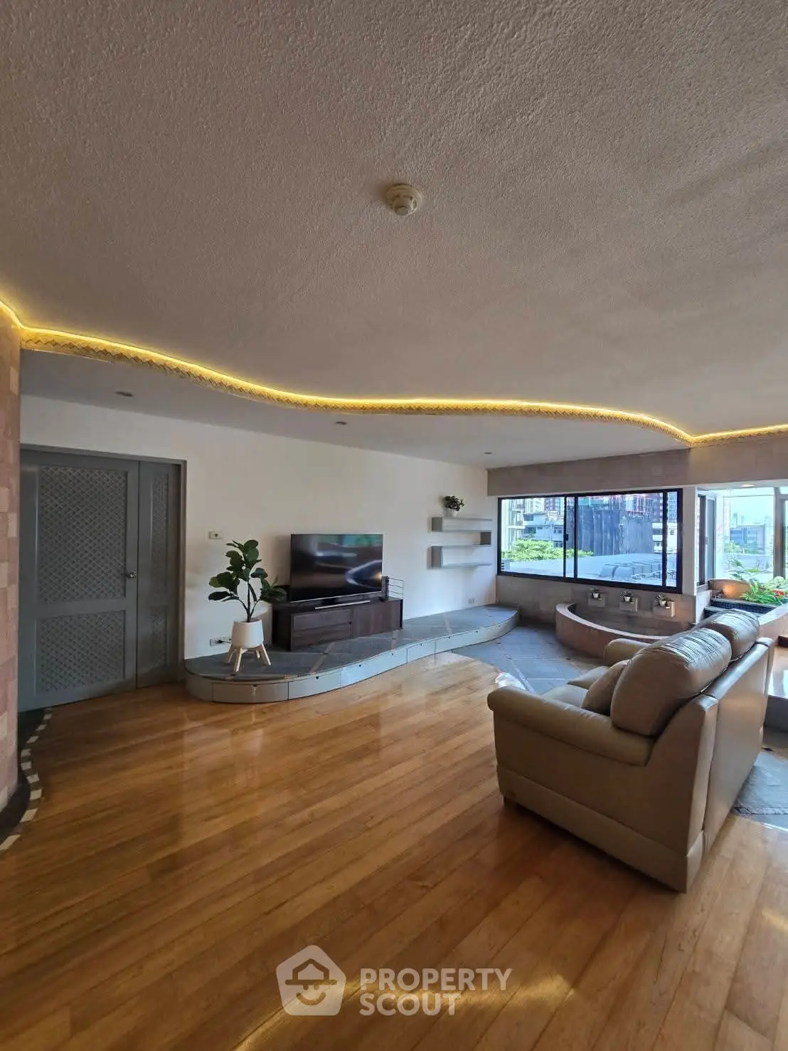 Spacious living room with modern decor and large windows offering natural light.