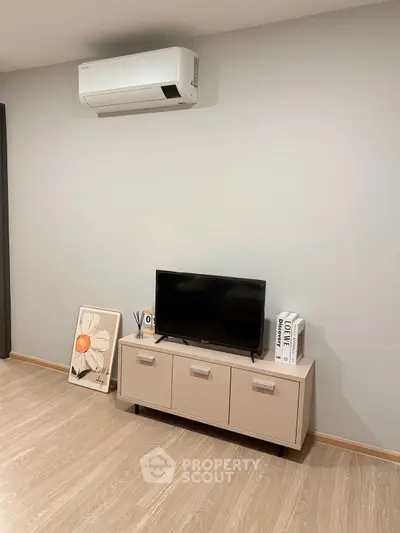 Modern living room with sleek TV stand and air conditioning unit, perfect for cozy entertainment.