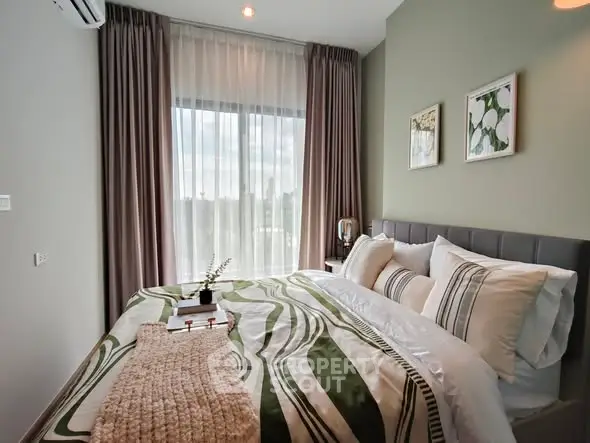 Cozy bedroom with stylish decor and large window offering natural light