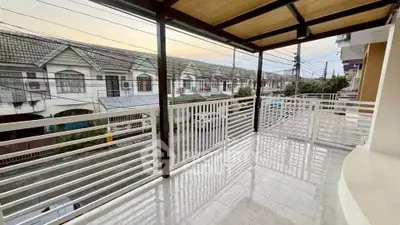Spacious balcony with modern railing overlooking residential street.