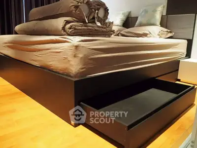 Modern bedroom with sleek storage bed and cozy linens.