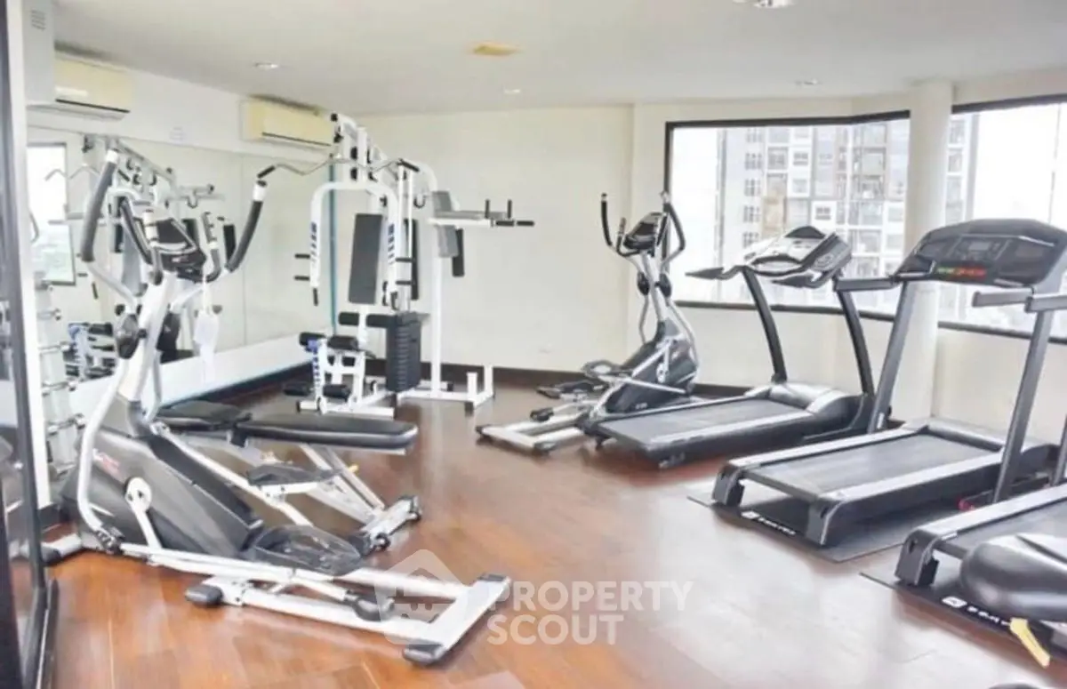 Spacious modern gym with state-of-the-art fitness equipment and large windows.