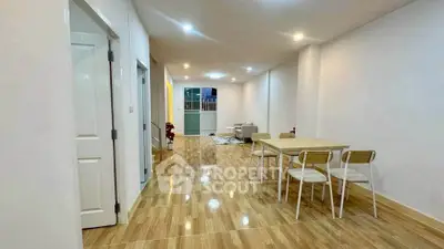 Spacious open-plan living and dining area with modern decor and wooden flooring.
