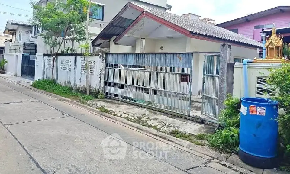 Charming suburban house with gated entrance and lush greenery
