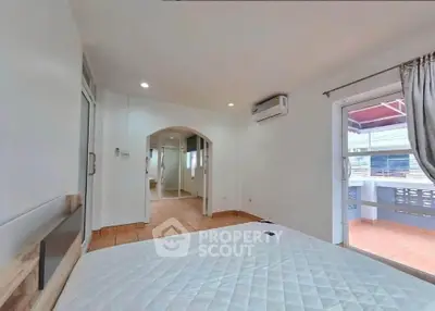 Spacious bedroom with balcony access and air conditioning in modern home.