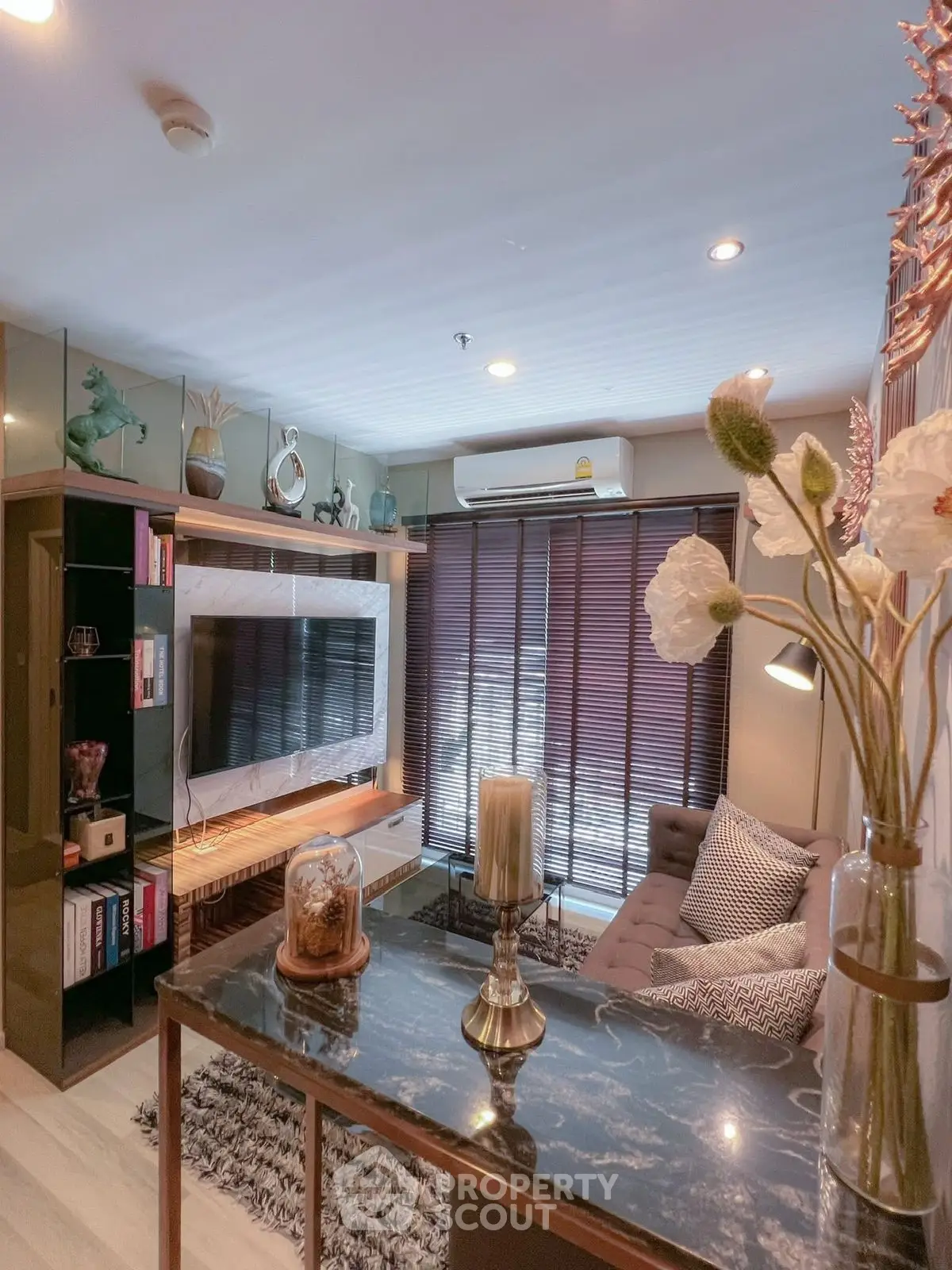 Stylish living room with modern decor, large TV, and cozy seating area.