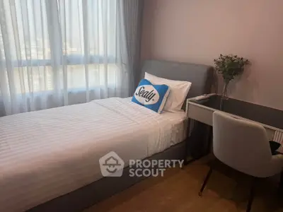 Cozy bedroom with modern decor and natural light, perfect for relaxation and productivity.