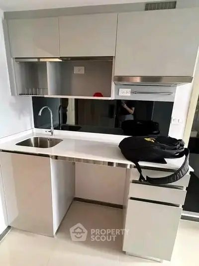 Modern kitchen with sleek cabinetry and stainless steel appliances in a compact layout.