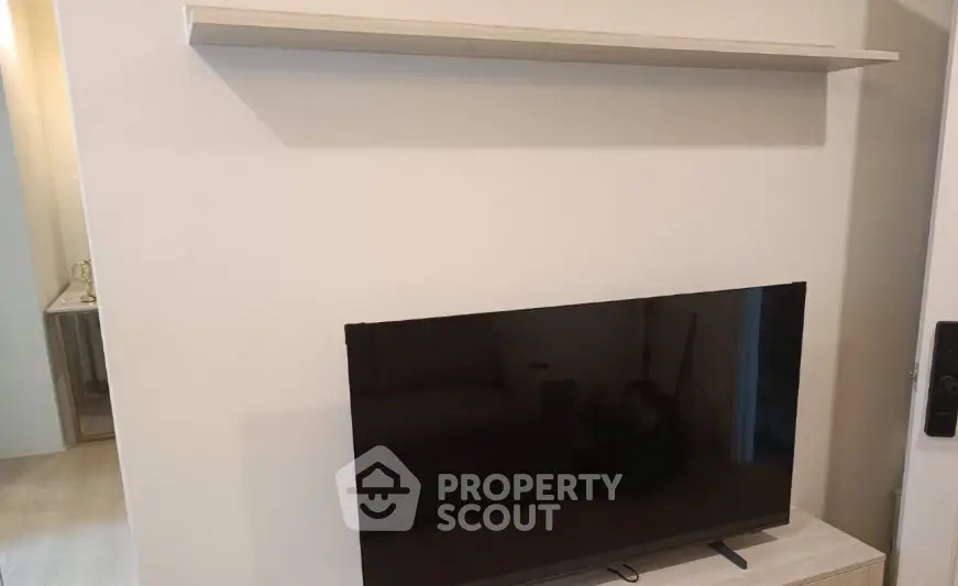Modern living room with mounted TV and minimalist shelf design.