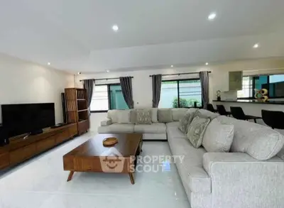Spacious modern living room with elegant furniture and large windows for natural light.