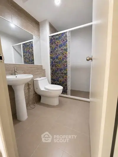 Modern bathroom with floral shower curtain and sleek fixtures