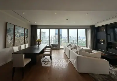 Luxurious living room with panoramic city view, elegant dining area, and modern decor in high-rise apartment.