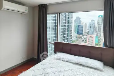 Modern bedroom with city view in high-rise apartment, featuring large windows and air conditioning.
