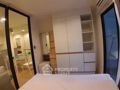 Modern bedroom with sleek storage and mirrored closet doors in a stylish apartment.
