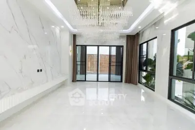 Luxurious marble-floored living room with elegant chandelier and large windows.