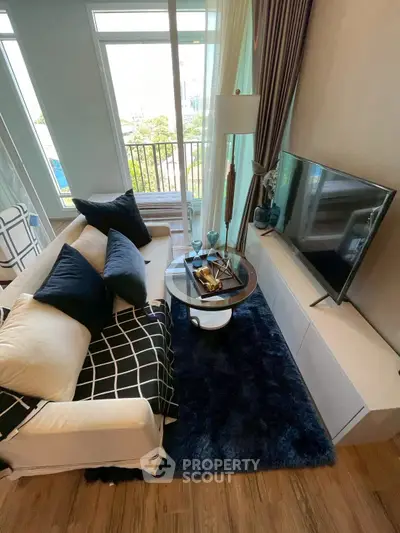 Stylish modern living room with cozy seating and large windows for natural light.