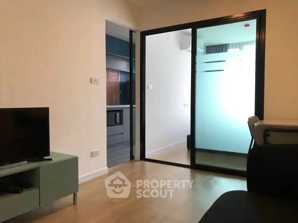 Modern living room with sliding glass door and sleek furniture in a stylish apartment.