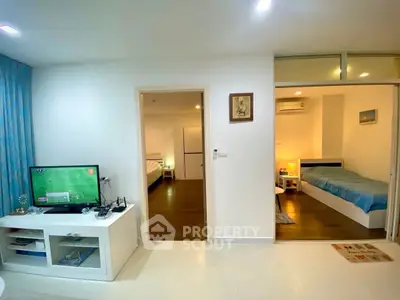 Modern apartment interior with cozy bedrooms and living area, featuring sleek furniture and ambient lighting.