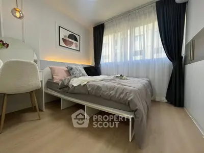 Modern bedroom with stylish decor and natural light, featuring a cozy bed and elegant furnishings.