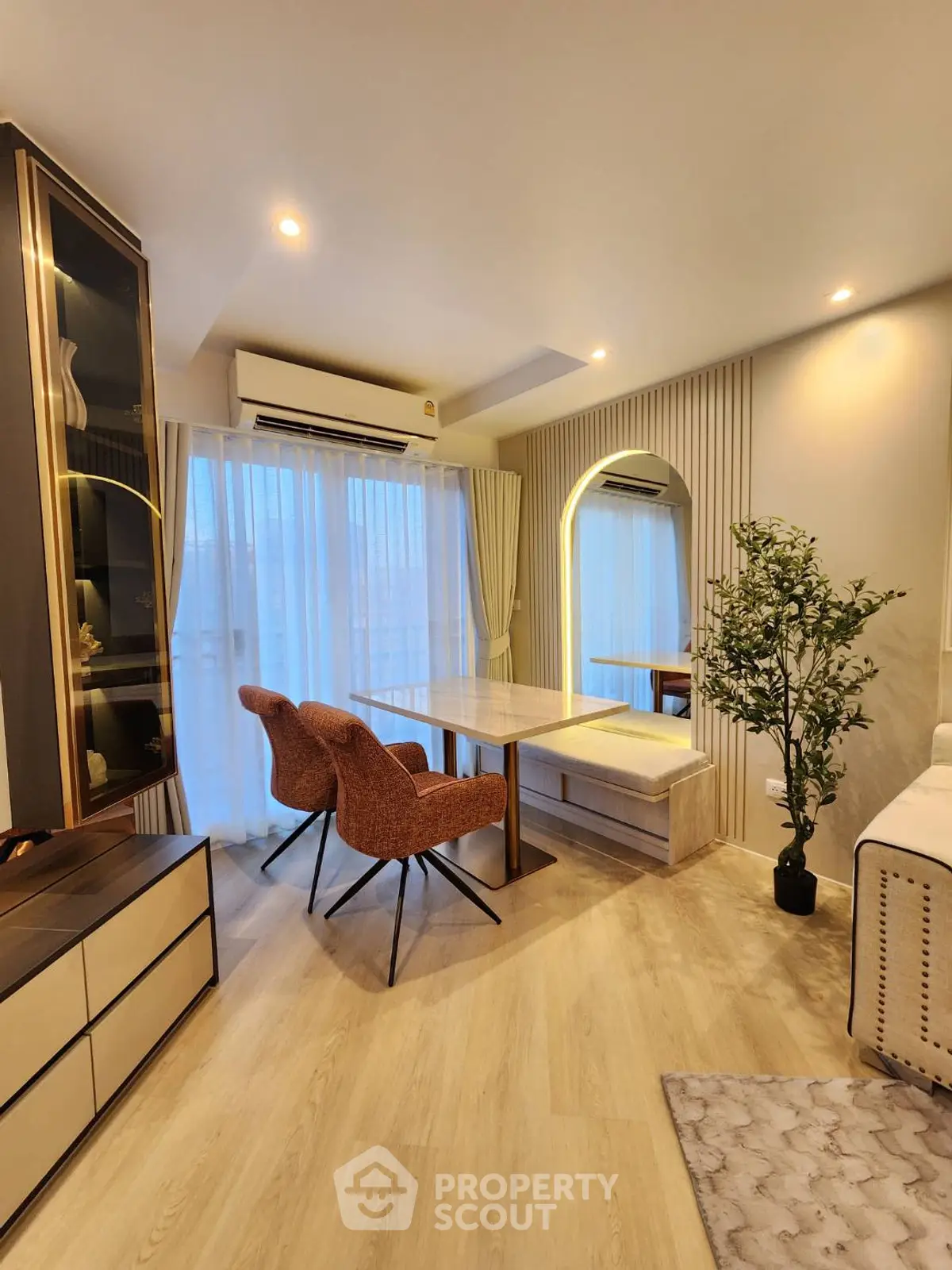 Modern living room with elegant dining area, featuring stylish chairs and a large window for natural light.