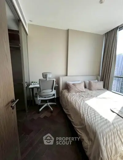 Modern bedroom with natural light and stylish decor in a high-rise apartment.