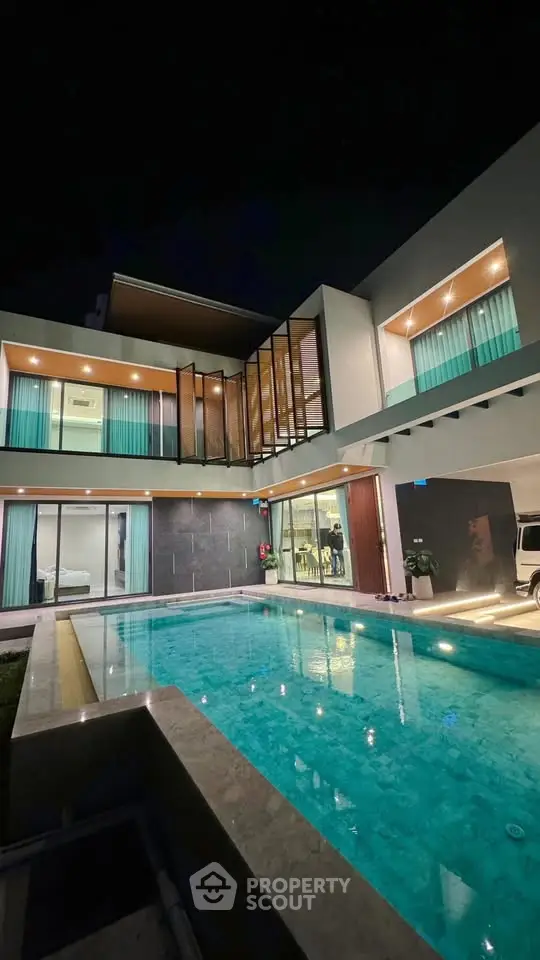 Luxurious modern villa with stunning pool and elegant architecture at night.