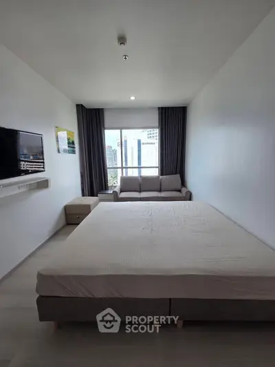 Modern bedroom with large bed, wall-mounted TV, and city view window.