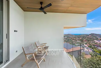 Spacious balcony with stunning panoramic views and modern seating, perfect for relaxation.