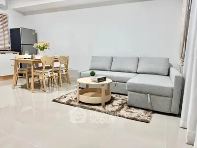 Modern living room with stylish furniture and open dining area, perfect for cozy gatherings.