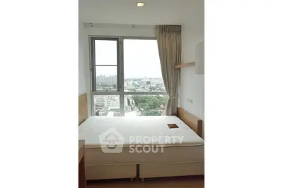 Bright bedroom with large window offering stunning city view, featuring a comfortable bed and elegant curtains.