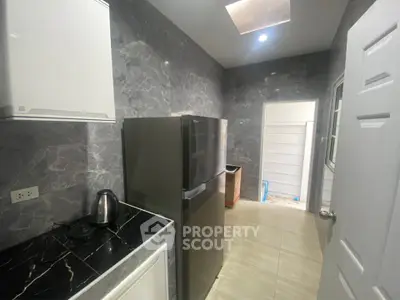 Modern kitchen with sleek marble walls and stainless steel fridge