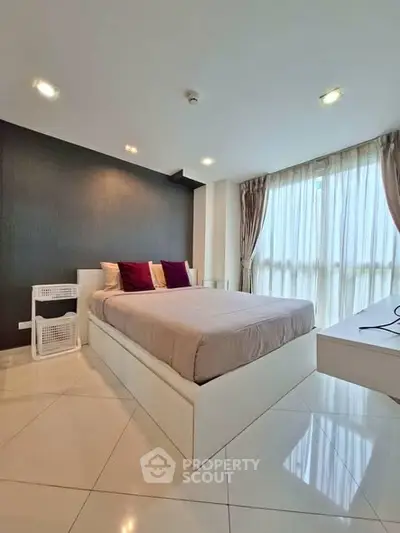 Modern bedroom with large windows and stylish decor in a high-rise apartment.