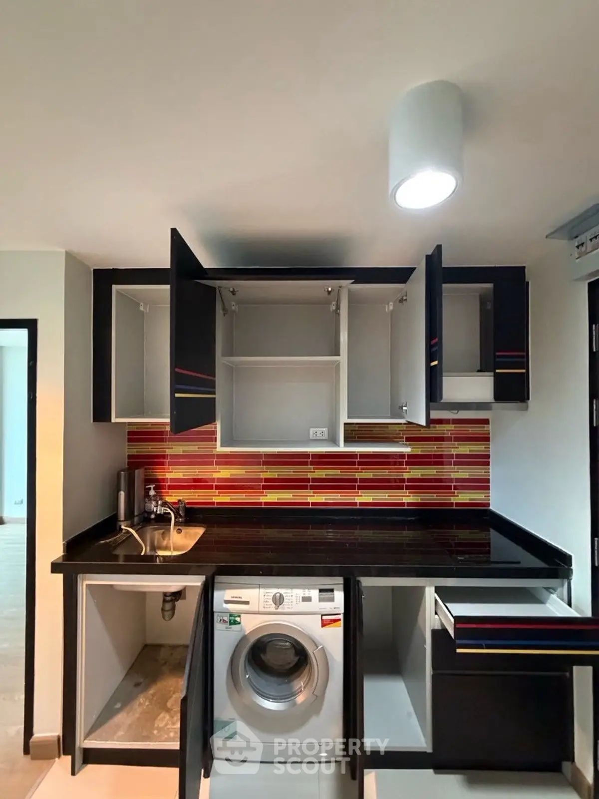 Modern kitchen with vibrant backsplash and built-in washing machine
