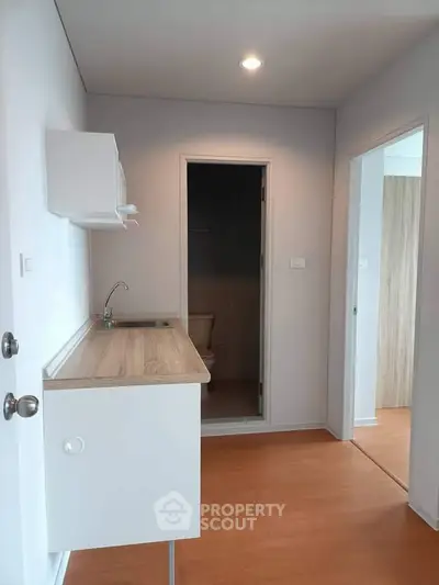 Compact kitchen area with wooden flooring and modern fixtures