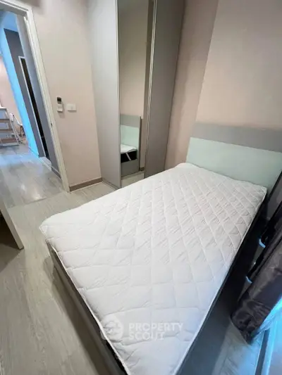 Cozy bedroom with single bed and mirrored wardrobe in modern apartment