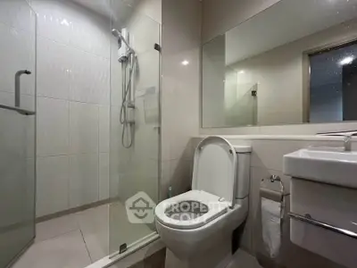 Modern bathroom with glass shower and sleek fixtures in a contemporary home.