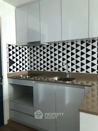 Modern kitchen with geometric backsplash and sleek cabinetry