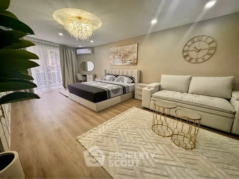 Luxurious bedroom with elegant decor and spacious layout, featuring a cozy seating area and modern lighting.