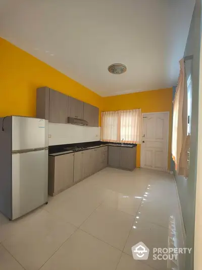 Spacious kitchen with modern cabinets and bright yellow accent wall