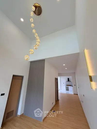 Spacious modern living room with high ceiling and elegant lighting fixture