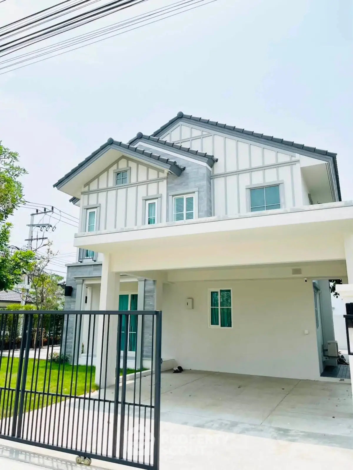 Charming modern two-story house with spacious driveway and lush green lawn.