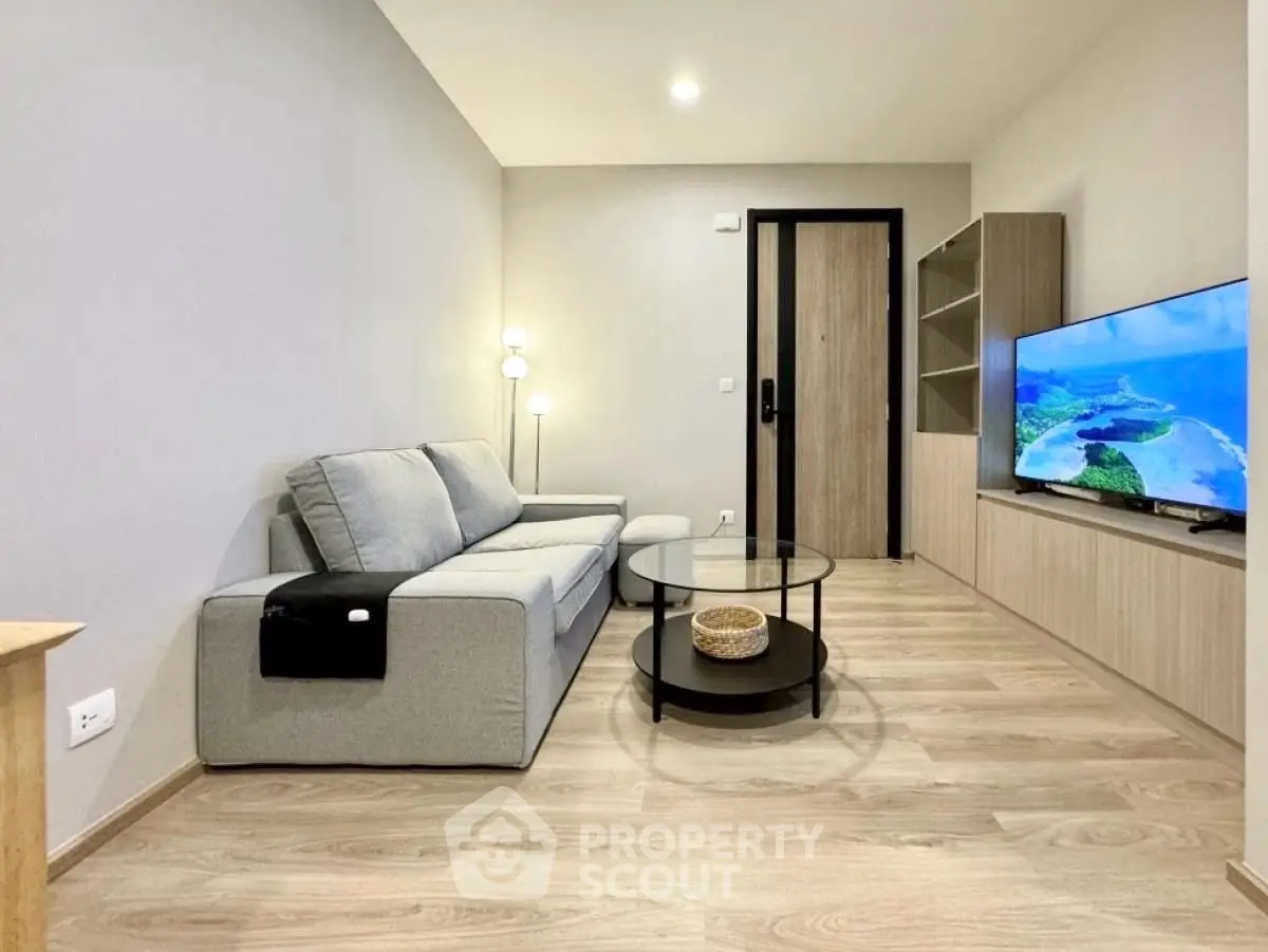 Modern living room with sleek furniture and flat-screen TV, perfect for relaxation.