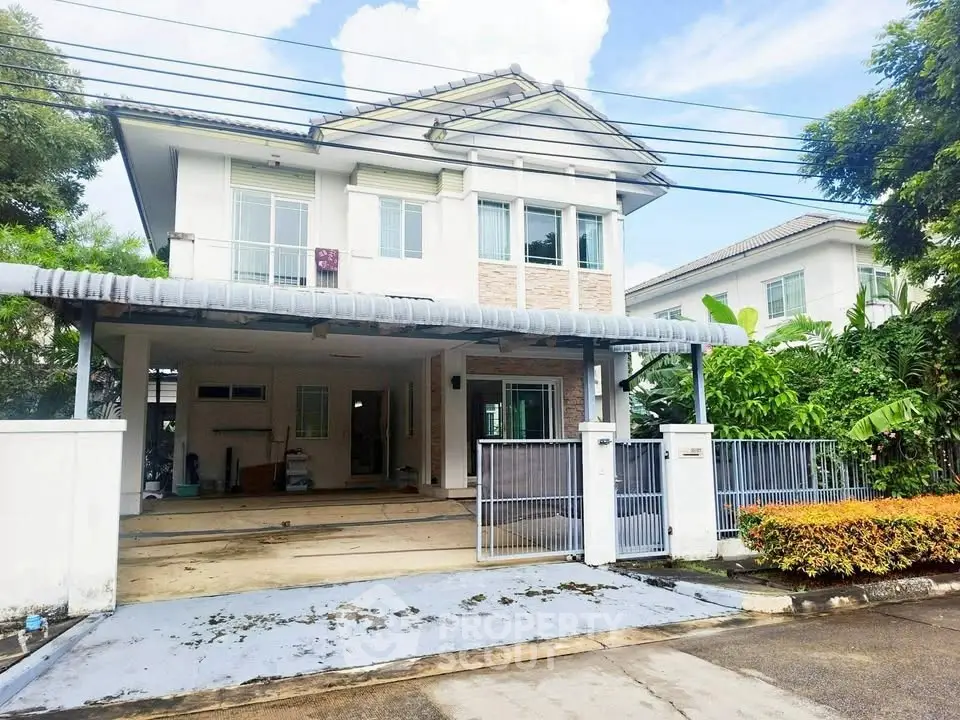 Charming two-story house with spacious driveway and lush greenery