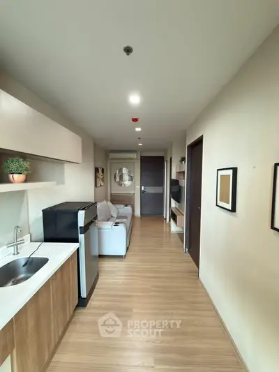 Modern apartment interior with open layout, featuring sleek kitchen and cozy living area.