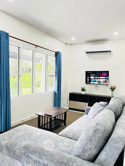 Spacious living room with modern decor and large window view