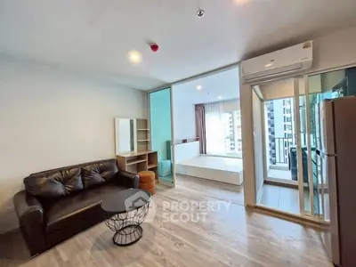 Modern open-plan living room with balcony view in urban apartment